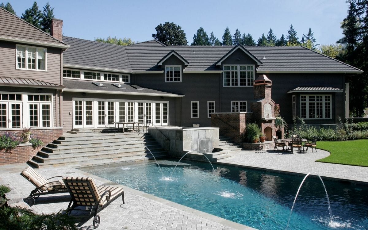 Exterior of an updated home with elaborate pool