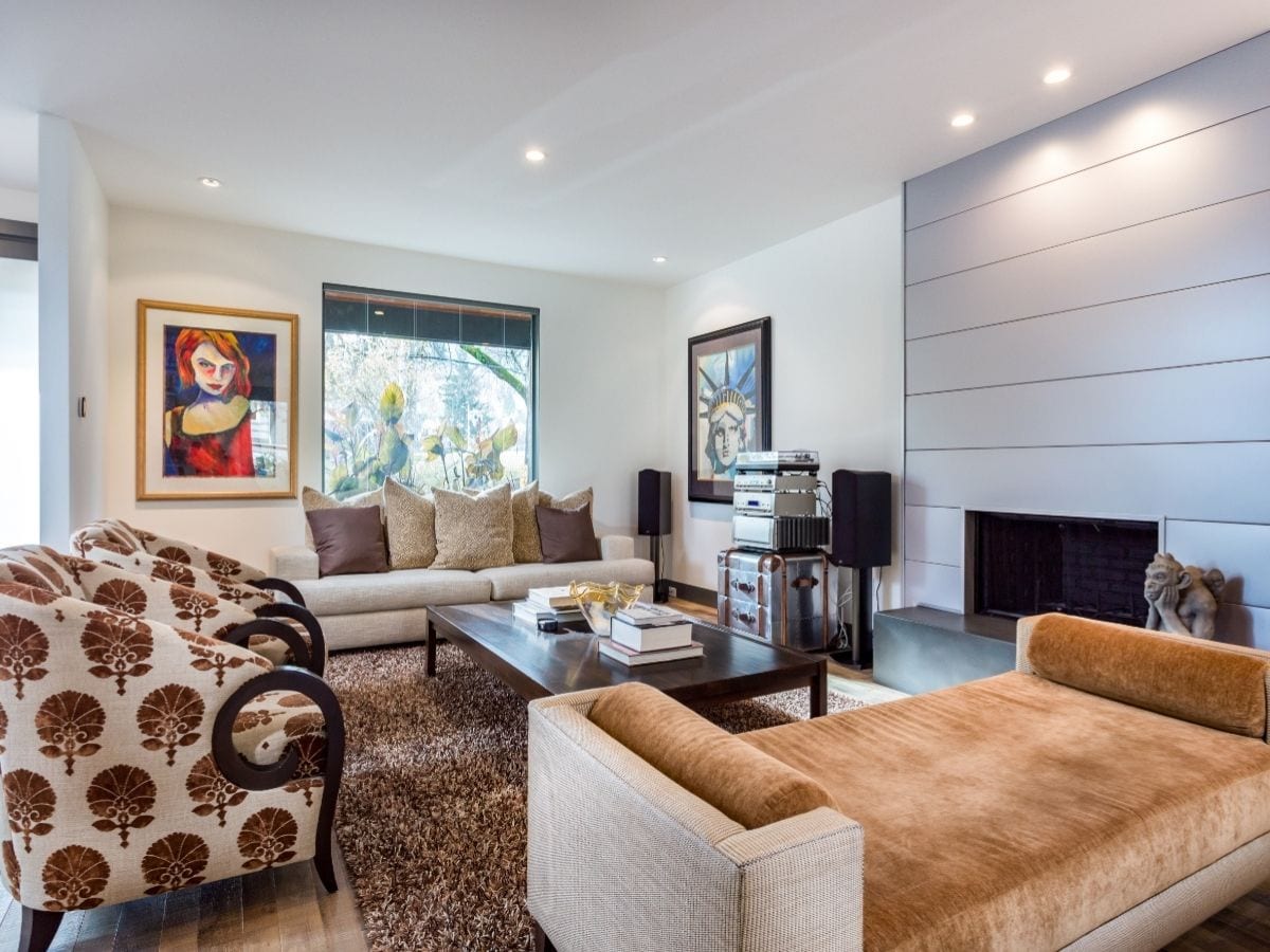 A luxury family room featuring modern furniture, artwork and a newly remodeled fireplace