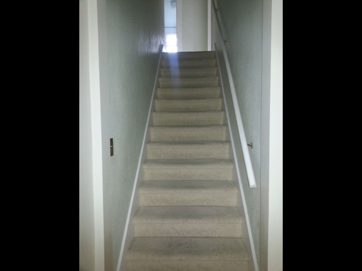 An outdated staircase with worn out carpeting